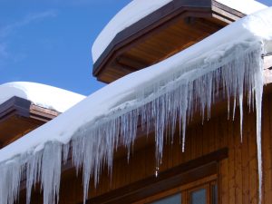 view of snow and frozen icicles on roof top